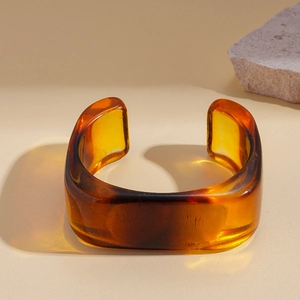 Detail view of amber resin cuff bracelet with irregular geometric design and natural texture