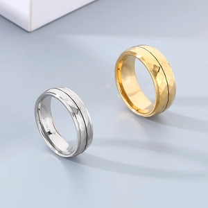 Detailed close-up of diamond-cut geometric rings in gold and silver finish with black grooves