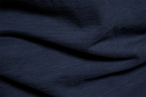 Close-up of deep blue slub cotton fabric texture on a men's V-neck summer T-shirt
