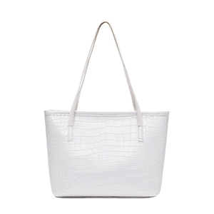 Close-up of white tote bag with crocodile pattern embossed texture and slim handles