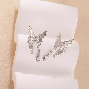 Artistic silver liquid metal butterfly stud earrings with elegant white pearls on display