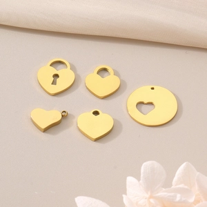 Pendentifs cœur dorés en styles creux et pleins sur fond de tissu beige