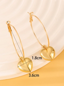 Detailed view of large gold heart hoop earrings with a polished mirror finish and measurements