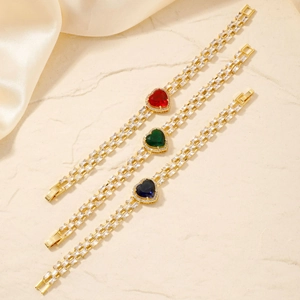 Detailed view of heart-shaped gemstones in red, green, and blue on a gold chain