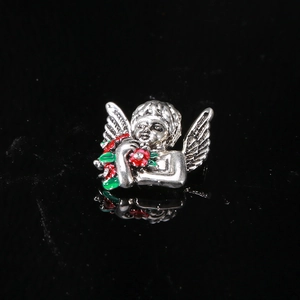 Macro shot of silver vintage angel brooch with red flower bouquet and crystal detail