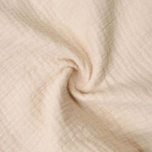 Close-up of soft beige muslin fabric texture on a cotton baby crib hanging organizer