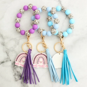 Detail of colorful silicone beaded keychain bracelets with leather tassels and mama charm
