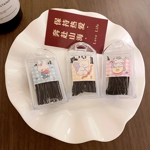 Three-pack set of black wave hair clips in cute cartoon cases displayed on a white plate