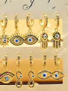 Macro shot of evil eye and hand of fatima earrings with colorful zircon stones