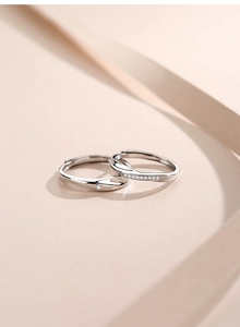Close-up of 925 silver Mobius rings with single and pave diamonds on soft pink background