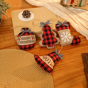 Détail de suspensions de Noël en toile de jute et tissu écossais sur une table en bois
