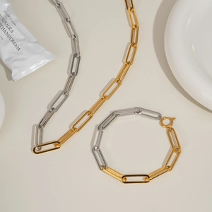 Detail view of two-tone paperclip chain necklace and bracelet set in gold and silver