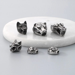 Detailed macro view of six animal head steel beads including wolf lion and dragon styles