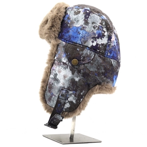 Winter bomber hat with ear flaps and brown faux fur lining on metal display stand