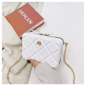 Close-up of white PVC jelly bag with quilted pattern and gold flower buckle detail