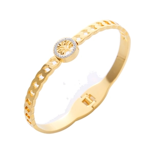 Detailed view of golden tree of life bangle with hollow heart pattern and pavé crystals