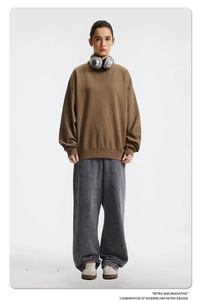 Dettaglio di felpa marrone e pantaloni grigi larghi in stile retrò casual da donna