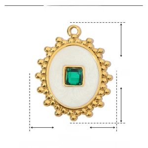 Detailed view of oval gold pendant with white enamel and green crystal stone