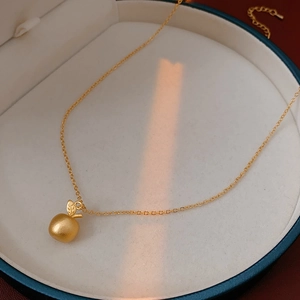 Detailed view of 18k gold plated apple pendant necklace in a luxury jewelry gift box