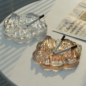 Nordic iceberg glass ashtray in clear and amber finish on a sunlit wooden table