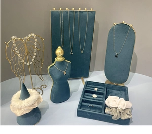 Detail view of emerald green velvet jewelry display set with golden wing-shaped stands
