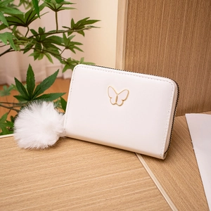 Minimalist white PU leather zip wallet for women featuring a golden butterfly logo and pom pom