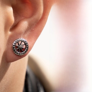 Detailed view of an antique silver cross star cartilage stud earring on ear