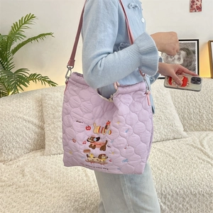 Quilted lavender shoulder bag with cute dog embroidery and adjustable pink strap on model