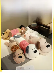 Détail d'un long coussin de chien en peluche rayé sur un lit avec tissu doux