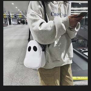 Ghost-shaped white PU leather crossbody bag worn by a model in a casual setting