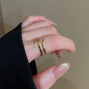 Detail view of a triple-layered gold spiral wrap ring with polished mirror finish