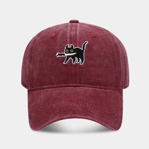 Close-up of high-quality embroidery featuring a cat with a knife on a washed cotton cap