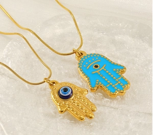 Detail of Hamsa Hand pendants with blue evil eye beads on gold stainless steel snake chains