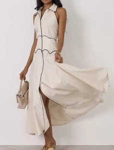 Détail de la robe maxi crème avec passepoil noir contrasté et couture de taille ondulée