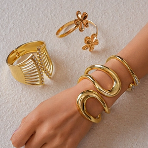 Details von 4-tlg. goldenen Blumen-Armreifen und gedrehten Armspangen mit Kristallen