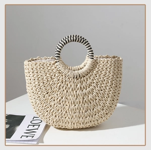 Detail of half-moon straw tote with black and white striped woven ring handles
