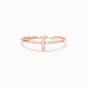 Macro detail of rose gold cross ring featuring sparkling cubic zirconia pave setting