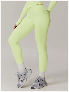 Detail of high-waist lime green yoga leggings featuring side pockets and breathable fabric