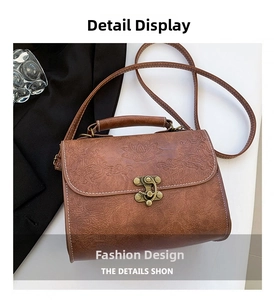 Detailed macro view of dark brown PU leather hand bag with floral embossing and retro lock