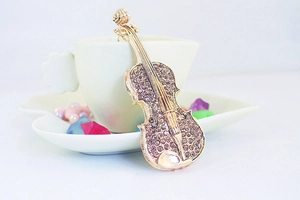 Gros plan du porte-clés violon doré avec strass marrons sur une tasse en forme de cœur