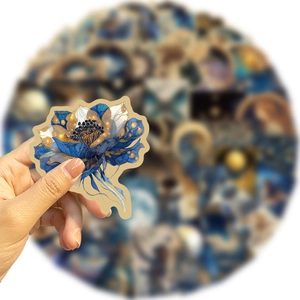 Vue détaillée d'un autocollant floral bleu avec des accents dorés élégants à la main
