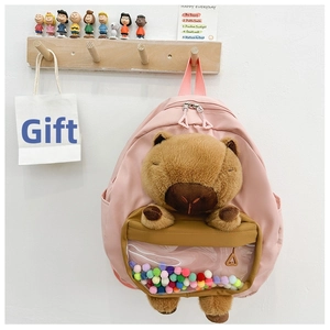 Pink school backpack featuring a plush capybara design and clear PVC ball compartment