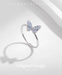 Macro shot of silver S925 butterfly ring with light blue crystals on white background