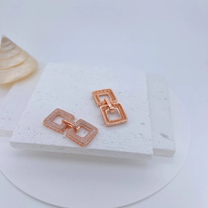 Rose gold square geometric earrings with micro-paxed zircon on white stone background