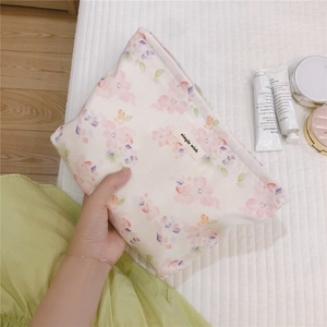 Close-up of floral makeup bag with simple wish label and cosmetic accessories