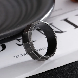 Detailed view of dark grey geometric faceted titanium steel ring with brushed finish