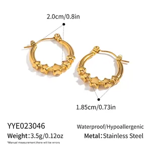 Macro detail of 18K gold plated stainless steel star hoop earrings on white background