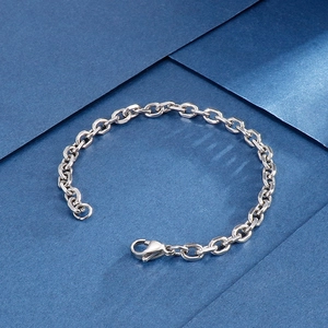 Vintage stainless steel O-chain bracelet with lobster clasp on a blue geometric background