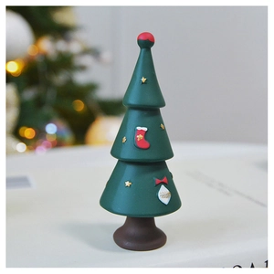 Close-up of a green resin Christmas tree ornament with festive red socks and golden stars