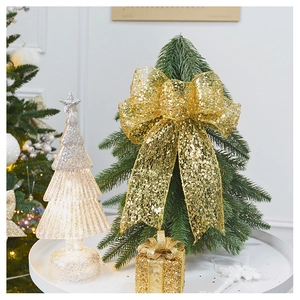 Sparkling champagne gold glitter bow with festive tree lamp and gift box decor